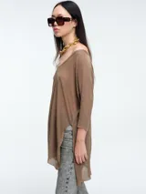 Sweater tipo túnica de tejido liviano con sutil transparencia y acabado brillante. Presenta escote en V, mangas largas relajadas y un corte amplio con largo asimétrico.