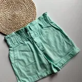 Short color amarillo pastel con cintura elastizada y detalle de botones frontales.