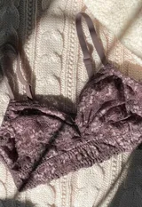 Bralette de encaje floral color lila, sin aro ni relleno, con breteles regulables y cierre trasero de tres posiciones.