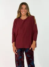 Sweater de punto color bordó, con cuello redondo, mangas largas y diseño holgado.