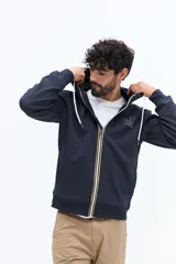 Campera de felpa azul marino con cierre frontal, capucha ajustable con cordones blancos y bolsillos canguro. Presenta un pequeño parche estampado en el pecho izquierdo.
