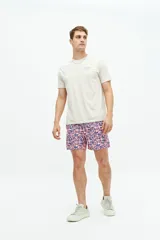 Short de baño con estampado geométrico en tonos azul y rosado, con cintura elástica y cordón de ajuste. Cuenta con bolsillos laterales y un bolsillo trasero.