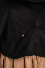 Top negro de 100% algodón, con tirantes finos, escote recto y volados dobles con detalles de encaje en el frente.