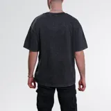 Remera negra con efecto acid wash, corte holgado y estampa frontal lisa.