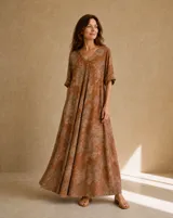 Vestido largo terracota con estampado floral difuminado, escote en V, mangas cortas holgadas y diseño amplio y fluido.