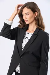 Blazer azul marino de corte clásico con solapa tradicional, botón frontal y bolsillos con solapa. Presenta forro interior a rayas en las mangas que pueden usarse dobladas.