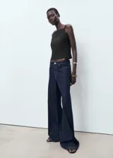 Top negro sin mangas de cuello cuadrado y tirantes anchos, con diseño recto y cierre de cremallera lateral.