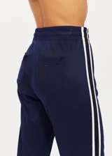 Pantalón deportivo azul marino de corte recto y talle medio, con cintura elástica ajustable con cordón, bolsillos delanteros y traseros, y una franja blanca a lo largo de la costura lateral.