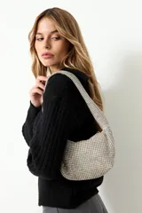 Cartera de mano tipo baguette, totalmente recubierta de cristales brillantes, con asa corta integrada y cierre superior.