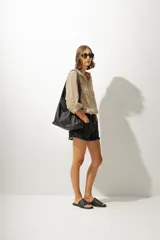 Short de jean de tiro medio con ruedo desflecado y cierre frontal con botón y cremallera.