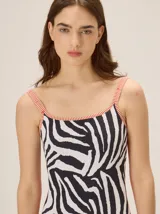 Malla enteriza de escote cuadrado, espalda redondeada y copas blandas, con estampado estilo animal print en tonos turquesa, azul y amarillo.