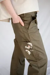 Pantalón de trabajo verde oliva, de tiro medio, confeccionado en gabardina de algodón. Presenta cinta utilitaria trasera, cintura ajustable, bolsillo para metro bordado y cinta reflectiva en los bajos.