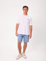 Remera blanca de manga corta y corte holgado de la marca Rusty, con estampado gráfico en la espalda con el logo de la marca en tonos grises.
