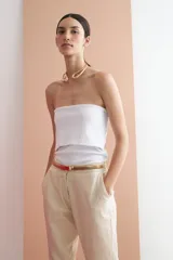 Pantalón de lino color dorado, de corte recto y tiro medio, con cinturón fino a tono.