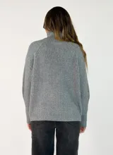 Sweater de tejido de punto acanalado en color marrón oscuro, con cuello alto y mangas largas con corte raglán.
