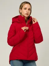 Campera ligera acolchada de la marca Tommy Hilfiger, con diseño de costuras en zigzag. Presenta cuello alto con capucha ajustable mediante cordones, cierre frontal de cremallera y dos bolsillos laterales también con cierre. El diseño es funcional y moderno.