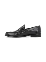 Mocasines de vestir tipo penny loafer en color negro, confeccionados en cuero con acabado brillante. Presentan costuras reforzadas en el empeine y suela de goma con pequeño tacón.
