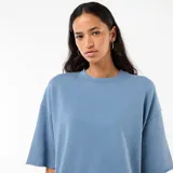 Camiseta de felpa color azul con mangas 3/4, cuello redondo y diseño holgado con terminaciones rústicas.
