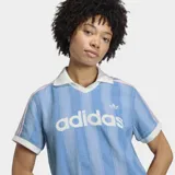 Remera de estilo deportivo inspirada en el fútbol, confeccionada en tejido denim de algodón con efecto lavado. Presenta un diseño de rayas verticales sutiles, cuello polo en color blanco, mangas cortas con bordes en contraste y el logo de la marca estampado en el frente.