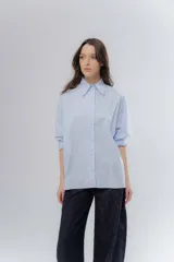 Camisa oversize celeste de algodón, con cuello camisero clásico y cierre frontal de botones.