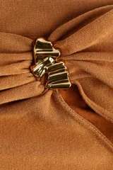 Top de punto fino color tostado con diseño asimétrico de un solo hombro. Presenta un panel fruncido en un brazo, manga corta con adorno metálico brillante y detalle drapeado en el lateral de la cintura.