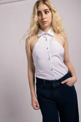 Top azul de corte halter, sin mangas, con cuello camisero y cierre frontal de botones coloridos.