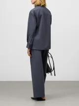 Pantalón de mujer color gris azulado, de corte recto y pierna ancha, tiro medio/alto, con trabillas para cinturón y bolsillos laterales y de vivo en la espalda.
