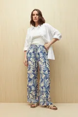 Pantalón ancho estampado en tonos azul y blanco, con diseño tropical de hojas. Cuenta con cintura elastizada y cordón ajustable.