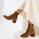 Botas tipo chelsea de cuero vacuno negro, con elásticos laterales, taco cuadrado y punta fina.