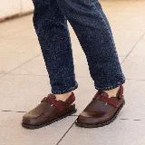 Zuecos de cuero marrón con tira de ajuste de velcro color borgoña.