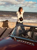 Riñonera de cuero con estampado animal print de vaca en blanco y negro, con correa regulable y cierre superior.