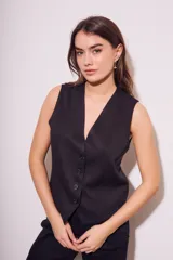 Chaleco de corte sastre con escote en V y cierre frontal de botones. Presenta un diseño sin mangas, entallado al cuerpo, confeccionado en una mezcla de lino y viscosa.