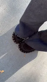 Zueco negro de cuero gamuza con plataforma forrada y tachas plateadas.