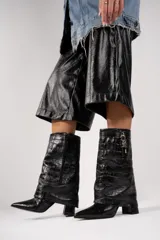 Bota de cuero color beige con punta fina, taco de 10cm y detalle de candado plateado en la caña.