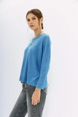 Remera azul de algodón peruano con textura jaspeada, de moldería holgada y buena caída, con mangas largas que se ajustan hacia la muñeca y se ensanchan debajo del brazo.