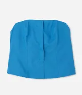 Blusa sin breteles color azul, con recortes delanteros, ruedo levemente abierto y cierre por cremallera lateral.