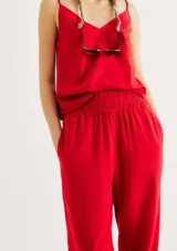 Pantalón de lino color rojo, de corte holgado y talle alto con cintura elástica fruncida. Presenta diseño recto que se estrecha ligeramente hacia los tobillos.