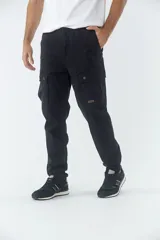 Pantalón cargo de corte slim, color negro, con bolsillos laterales con solapa y botones metálicos. Cuenta con cierre frontal, botón en la cintura y pasacintos.