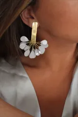 Aros colgantes con base dorada y apliques colgantes de pétalos blancos.