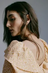 Blusa de viscosa con estampado floreado en tonos tostados y blancos, escote cuadrado, mangas largas abullonadas con puños elásticos y volados, y detalle fruncido bajo el busto.