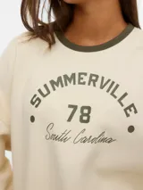 Buzo de manga larga color crudo con cuello redondo, diseño holgado y estampa frontal en tono verde oscuro con la inscripción "SUMMERVILLE 78 South Carolina".
