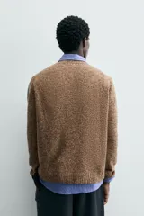 Jersey de punto de lana con textura jaspeada, corte regular fit, cuello redondo y mangas largas con puños y ruedo en rib.