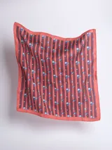 Pañuelo cuadrado de seda color ladrillo con rayas verticales marrones y estampado de pequeñas flores celestes.