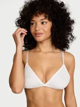 Bralette de encaje blanco sin aros, con copas triangulares y tirantes finos ajustables.