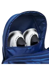 Mochila Under Armour de color azul marino, diseñada con tirantes acolchados y texturizados para mayor comodidad, correa ajustable en el pecho con hebilla y el logo de la marca en relieve.