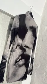 Minivestido ajustado con cuello alto y mangas largas acampanadas, con estampado abstracto en blanco y negro.