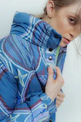 Campera puffer azul con estampado de motivos geométricos y figuras como estrellas de mar y sirenas.