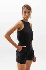 Short de lino negro con cintura alta, pinzas delanteras, bolsillos laterales y cierre frontal con gancho metálico.