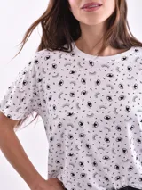 Remera de manga corta color beige con estampado de bananas en tonos amarillo, naranja y rosado.