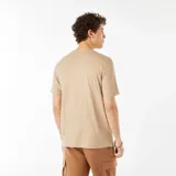 Remera color beige con estampado blanco en el frente que incluye un diseño gráfico de sol, olas y palmeras, y el texto 'Chill Zone Ahead'.